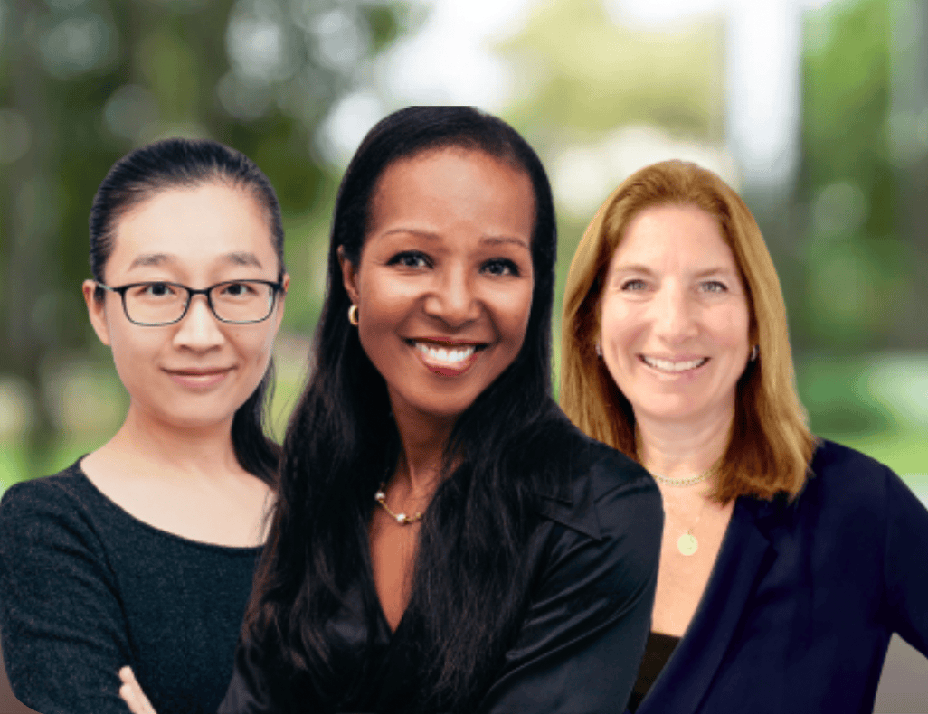 Three professional women smiling together outdoors, representing a collaborative, welcoming team in a professional setting.